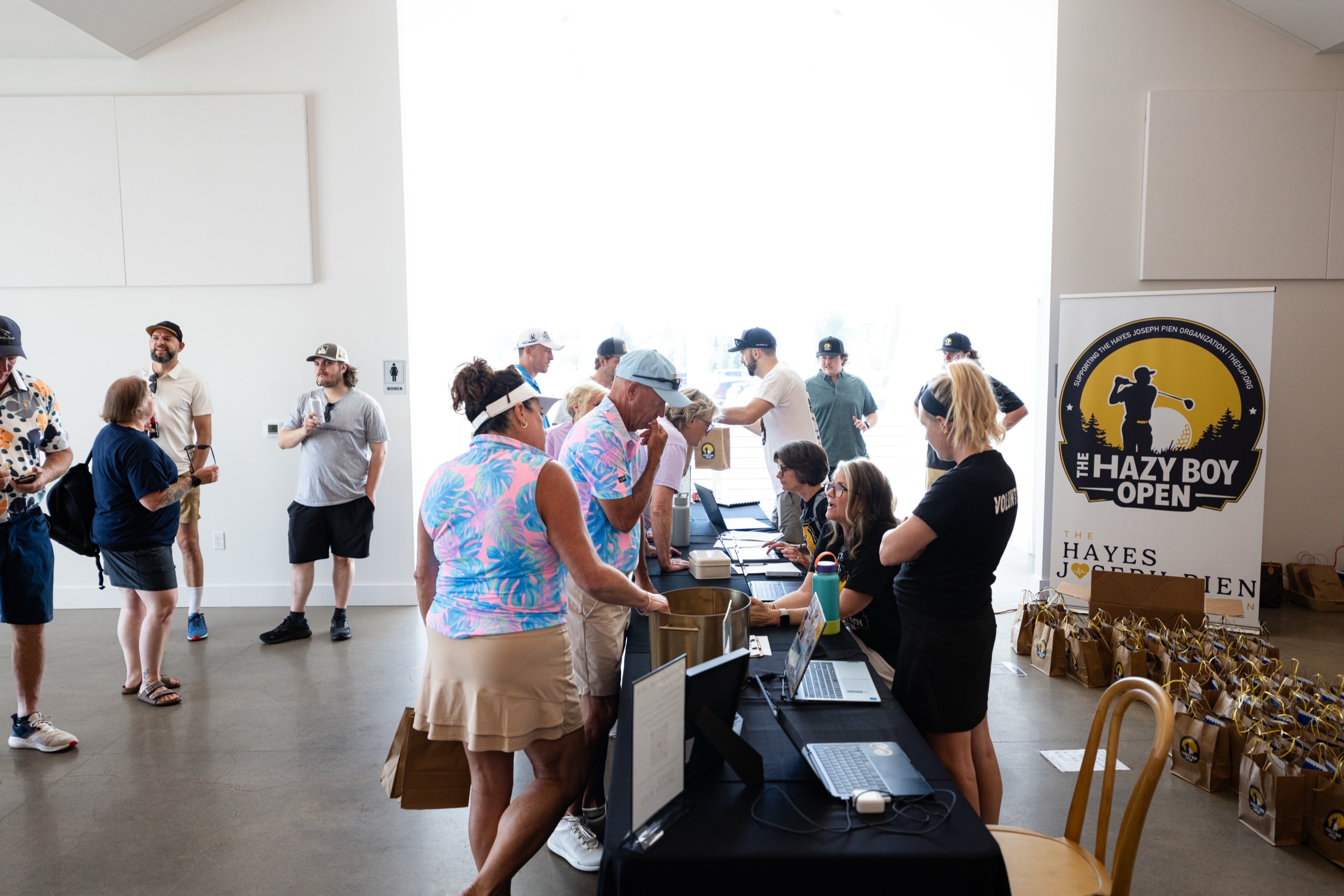 Volunteers checking golfers in at laptops